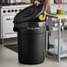 A black Advantage Supplies 44 gallon round trash can with lid.