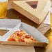 A single slice of pepperoni pizza in a triangular kraft clamshell box with a clear window, placed on a wooden table with drinks nearby.