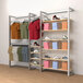 A white wall-mounted retail display with clothes, shoes, and boxes on shelves and faceouts.