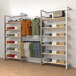 A white retail display with shelves, clothes, and a hangrail.