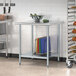 A galvanized steel undershelf on a metal work table with a bowl on it.