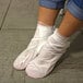 A person wearing white plastic over their feet.