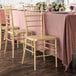 Lancaster Table & Seating gold chiavari chairs on a table with a pink tablecloth.