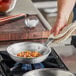 A Vigor A3000 Series aluminum fry pan with food cooking on a stove.