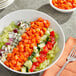 A bowl of salad with diced carrots and vegetables.