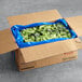 A blue plastic bag full of Savor Imports broccoli florets.