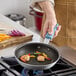 A person cooking shrimp and vegetables in a Vigor A3000 Series aluminum fry pan with QuanTanium non-stick coating.