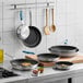A group of Vigor aluminum frying pans on a counter.