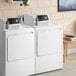 A white GE front load commercial dryer.