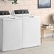 A white GE top load commercial washer with a lid.