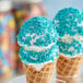 An ice cream cone with Yum Crumbs Berry Blue crumb topping on top.