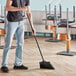 A man sweeping the floor with an O-Cedar commercial broom.