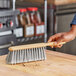 A person using an O-Cedar counter duster to clean a wooden surface.