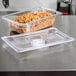 A Vollrath 1/4 size clear polycarbonate plastic lid on a food container on a counter.