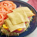 A sandwich with Armored Fresh vegan sliced pepperjack cheese, tomatoes, and sprouts.