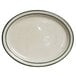 A white Tuxton oval china platter with a green speckled rim.
