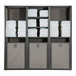 A Grosfillex Sunset Gray and Volcanic Black triple unit towel valet with towels on shelves.