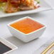 A bowl of Kari-Out Company Duck Sauce on a table in an Asian restaurant.