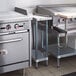 A Regency galvanized steel undershelf for a work table under a counter in a kitchen with a stove and sink.