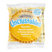 A package of Smucker's Uncrustables peanut butter and honey sandwiches with wheat bread with a yellow circle on it.