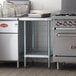 A Regency adjustable undershelf on a stainless steel work table.