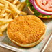 A fried unMEAT vegan chick'n burger with fries on a tray.