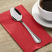 A Choice Milton stainless steel teaspoon on a red napkin.