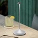 A Zafferano America silver leaf table lamp on a table next to a drink with a lemon and lime slice.