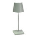 A Zafferano America Poldina Pro Mini sage table lamp on a white table stand.