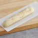 A long loaf of Bridor par-baked French half baguette on a cutting board.