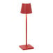 A red Zafferano America Poldina Pro table lamp on a white background.