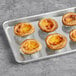 A baking tray of Bridor Pastel de Nata on a gray surface.