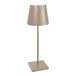 A Zafferano America Poldina Pro desk lamp with a sand-colored shade on a white pole.