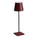 A Zafferano America Poldina Pro cordless rechargeable table lamp with a red shade and stand.