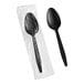 A black plastic wrapped teaspoon in a plastic bag.