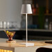 A white Zafferano America Poldina Pro table lamp on a counter.