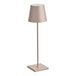 A Zafferano America Poldina Pro table lamp with a white shade on a sand-colored stand.