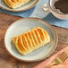 A plate with a Bridor Pumpkin Spice and Cream Cheese Danish and a cup of coffee.