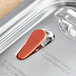 A close-up of a red open button on a silver Vigor steam table cover.