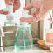 A person using a Dial Fresh Pear foaming hand soap pump to dispense white soap.