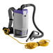 A ProTeam backpack vacuum with a hose attached.