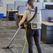 A woman vacuuming a floor with a ProTeam GoFit 6 PLUS backpack vacuum.