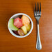 A Tuxton bright white china bouillon cup filled with fruit on a table.