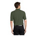 A man wearing a Port Authority Clover Green Silk Touch Pique polo shirt.