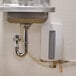 A metal sink with an Advance Tabco tankless electric water heater above it.