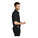 A man wearing a black Port Authority silk touch pique polo shirt.