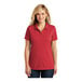 A woman wearing a rich red short sleeve Port Authority polo shirt with a collar.