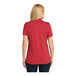 A woman wearing a rich red Port Authority Dry Zone short sleeve polo.