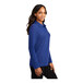 A woman wearing a royal blue Port Authority long sleeve polo shirt.