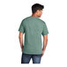 A man wearing a Port & Company laurel green short sleeve t-shirt.